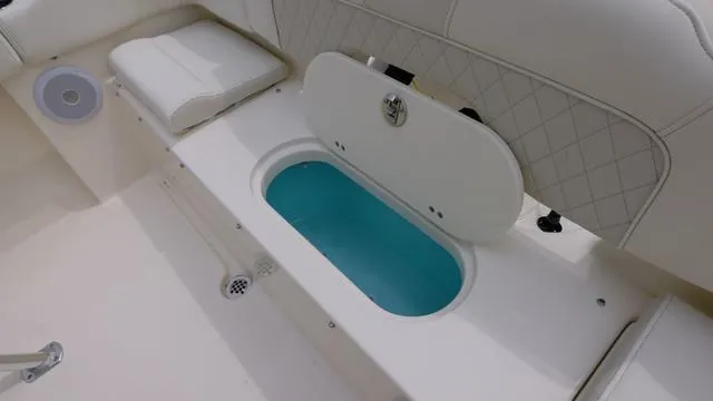 Slide: The Image of 2025 Key West 203 FS boat interior with open storage compartment and cushioned seating. - 5