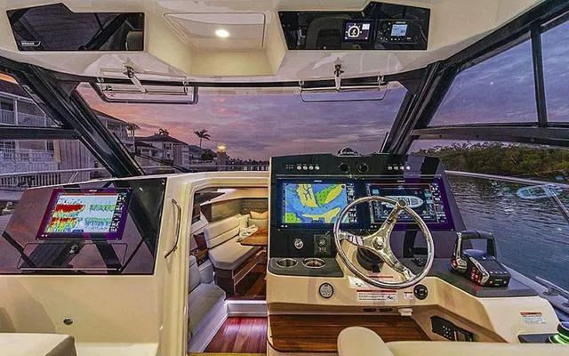 Slide: The Image of Luxurious 2025 Boston Whaler 365 Conquest helm with advanced navigation systems at sunset. - 2