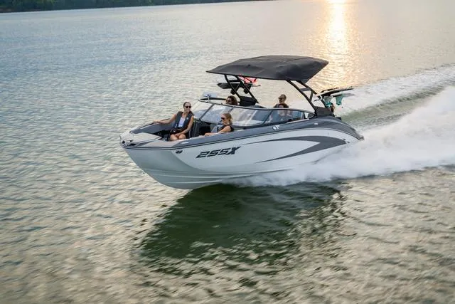 Slide: The Image of 2025 Yamaha Boats 255XE speeding on a serene lake at sunset. - 3
