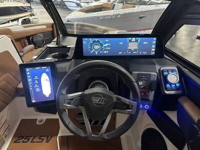Slide: The Image of 2025 Malibu 25 LSV boat dashboard with advanced digital controls and steering wheel. - 10