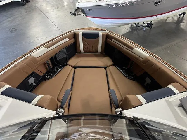 Slide: The Image of 2025 Malibu 25 LSV boat interior with luxurious brown and black seating. - 11