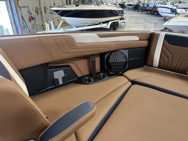 Slide: The Image of 2025 Malibu 25 LSV boat interior with tan leather seating and cup holders. - 12