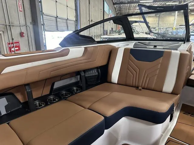 Slide: The Image of 2025 Malibu 25 LSV boat interior with brown and white seating. - 13