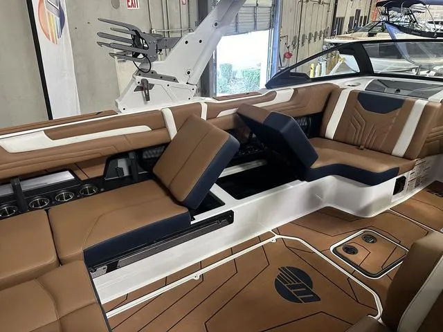 Slide: The Image of 2025 Malibu 25 LSV boat interior with brown and white seating, modern design. - 15