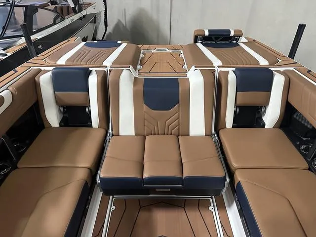 Slide: The Image of 2025 Malibu 25 LSV boat interior with luxurious brown and navy seating. - 16