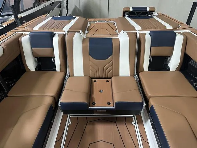Slide: The Image of 2025 Malibu 25 LSV boat interior with brown, white, and navy seating. - 17