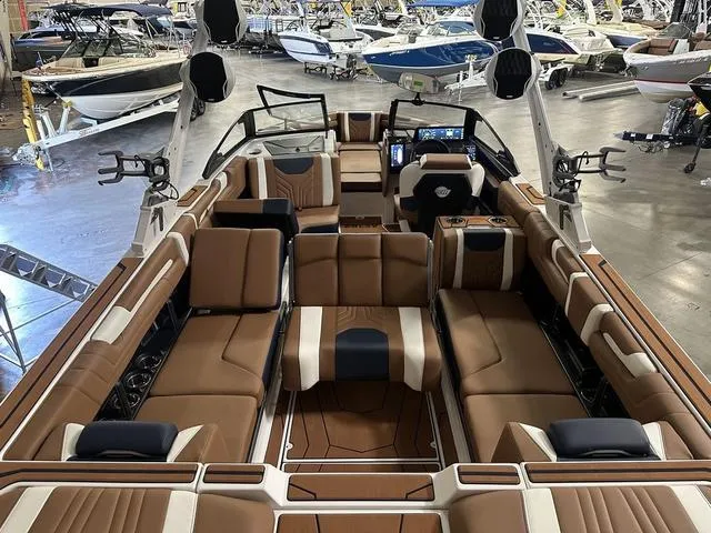 Slide: The Image of 2025 Malibu 25 LSV boat interior with luxurious seating in a showroom. - 18