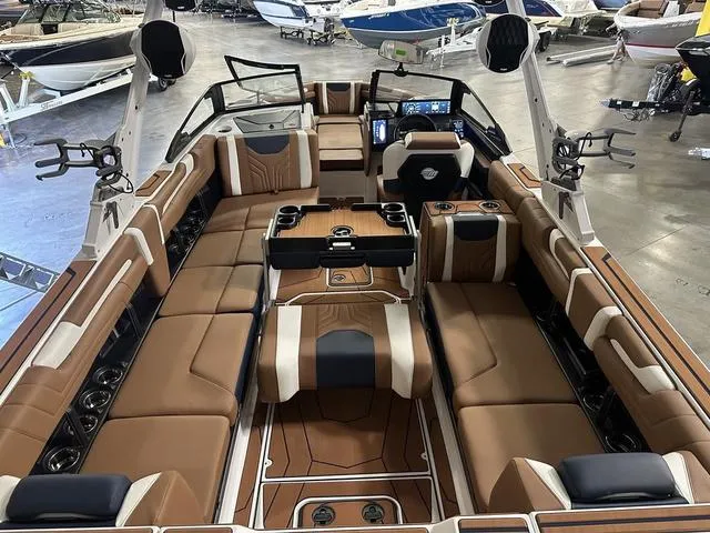 Slide: The Image of 2025 Malibu 25 LSV boat interior with luxurious brown seating and modern dashboard. - 19