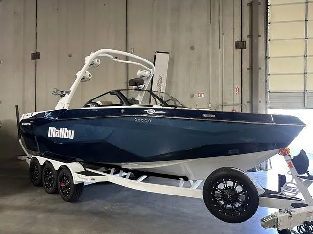 Slide: The Image of 2025 Malibu 25 LSV boat in a garage, sleek design on a trailer. - 6