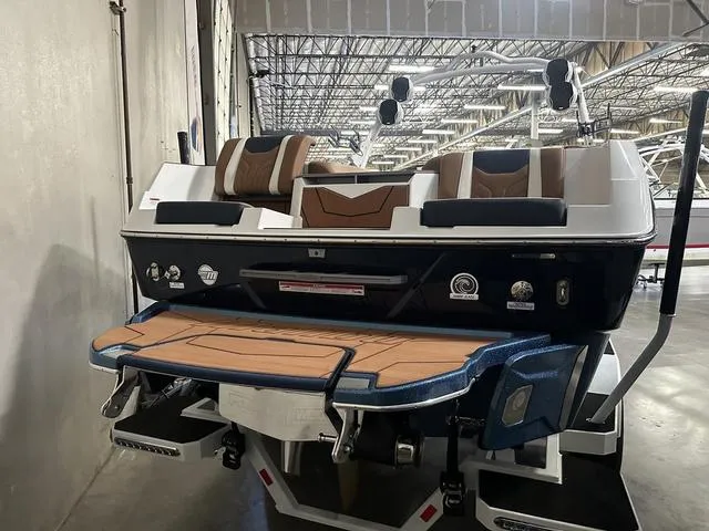 Slide: The Image of 2025 Malibu 25 LSV boat in warehouse, featuring sleek design and modern seating. - 7