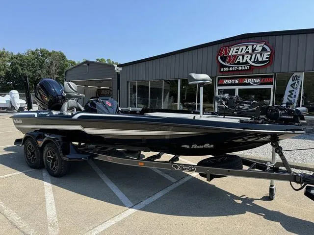 Slide: The Image of 2025 Bass Cat Cougar FTD boat at dealership, sleek black design, dual-axle trailer. - 10