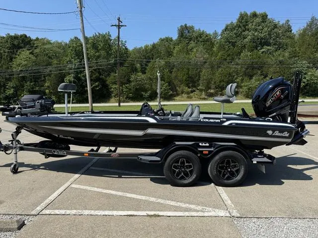 Slide: The Image of 2025 Bass Cat Cougar FTD boat on trailer, parked outdoors, side view. - 17