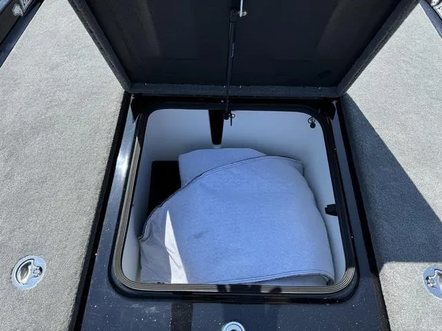 Slide: The Image of 2025 Bass Cat Cougar FTD storage compartment with open lid and stored items. - 20