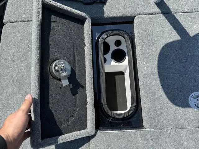 Slide: The Image of 2025 Bass Cat Cougar FTD boat storage compartment with open lid and lock mechanism. - 22