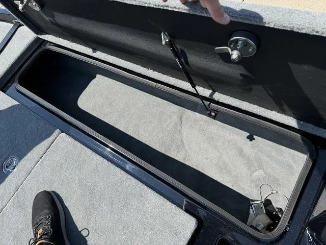 Slide: The Image of 2025 Bass Cat Cougar FTD storage compartment with open lid and visible interior. - 24