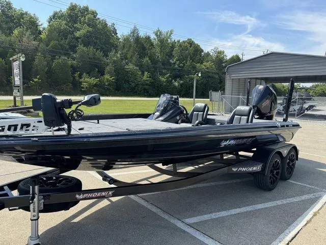 Slide: The Image of 2025 Phoenix 921 ELITE boat on trailer in parking lot, surrounded by trees. - 14