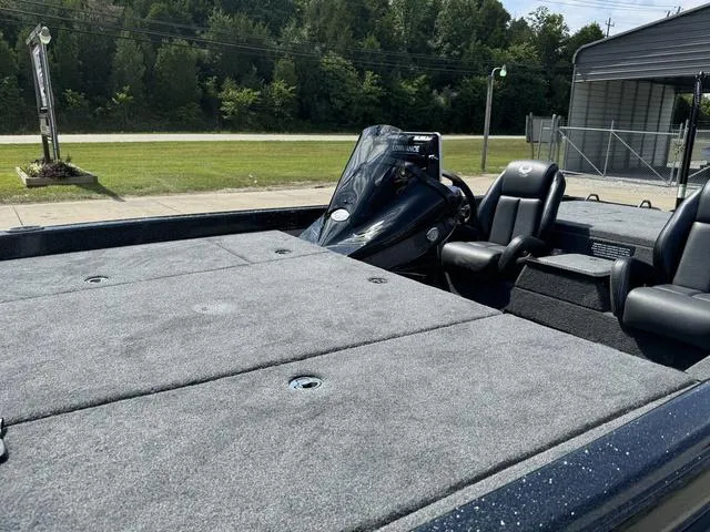 Slide: The Image of 2025 Phoenix 921 ELITE boat with spacious deck and seating, parked outdoors. - 15