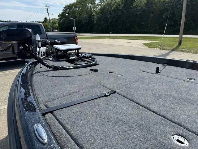 Slide: The Image of 2025 Phoenix 921 ELITE boat deck with fishing equipment, parked near a road. - 16