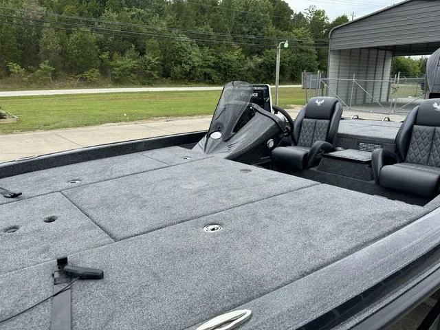 Slide: The Image of 2025 Phoenix 920 Elite boat with spacious deck and dual seating, parked outdoors. - 17