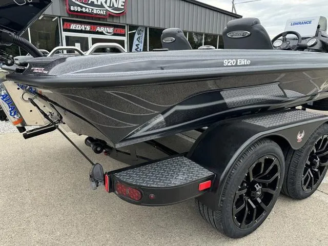Slide: The Image of 2025 Phoenix 920 Elite boat on trailer, sleek design, black wheels, parked outside dealership. - 4