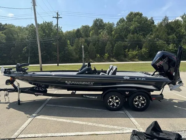 Slide: The Image of 2025 Phoenix 721 ZXL boat on trailer, parked outdoors, surrounded by trees. - 24
