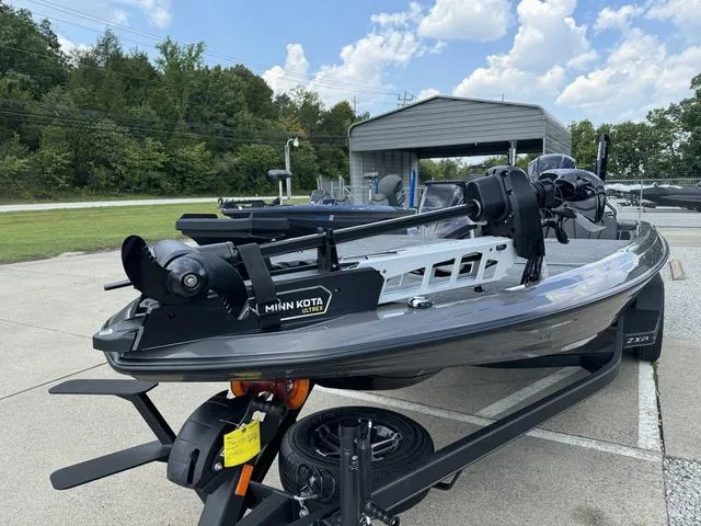 Slide: The Image of 2025 Skeeter ZXR21 boat with Minn Kota motor on trailer, parked outdoors. - 13
