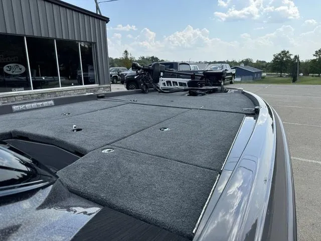 Slide: The Image of 2025 Skeeter ZXR21 boat with spacious deck, parked outdoors under a clear sky. - 7