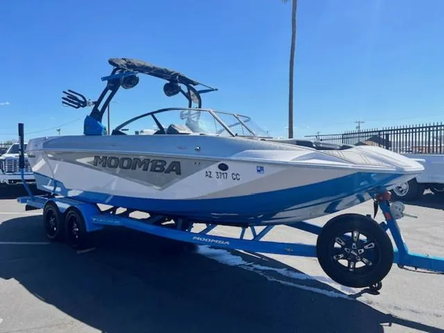 Slide: The Image of 2021 Moomba Makai boat on trailer, blue and white design, parked outdoors. - 4