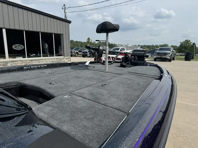 Slide: The Image of 2025 Skeeter ZXR20 boat with spacious deck and seating, parked near a building. - 9