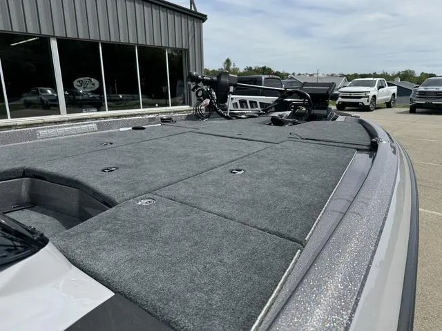 Slide: The Image of 2025 Skeeter ZXR20 boat with spacious deck, parked near a showroom. - 8