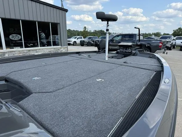 Slide: The Image of iKon VLX 21 boat deck, 2025 model, parked outdoors with vehicles in the background. - 8