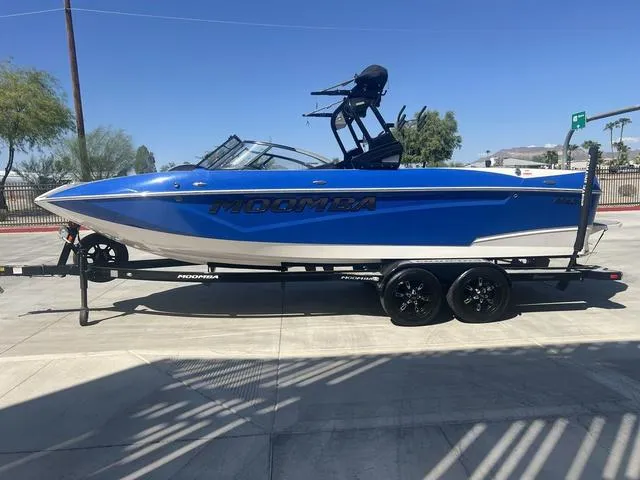 Slide: The Image of 2021 Moomba Makai boat in blue on a trailer, parked outdoors. - 5