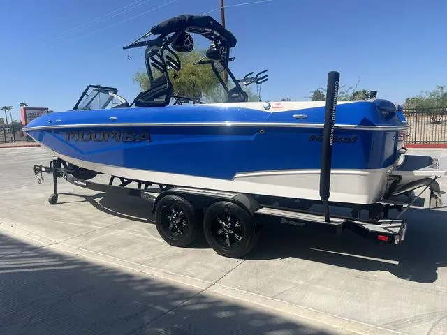 Slide: The Image of 2021 Moomba Makai boat in blue on a trailer, parked outdoors. - 6