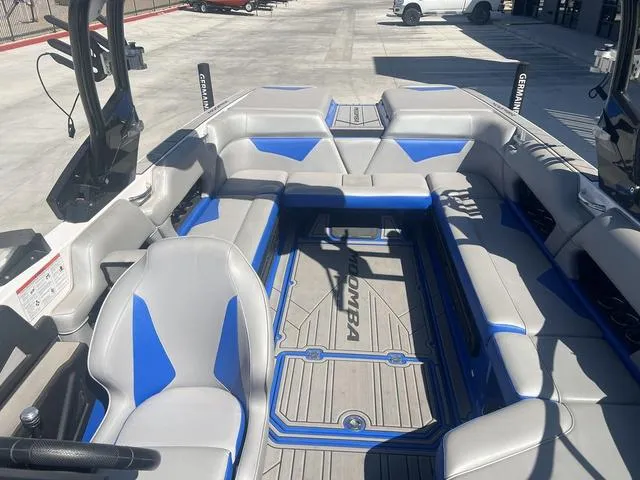 Slide: The Image of 2021 Moomba Makai boat interior with gray and blue seating, docked outdoors. - 8