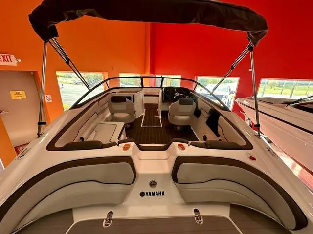 Slide: The Image of 2024 Yamaha SX190 boat interior with seating and steering wheel in showroom. - 5
