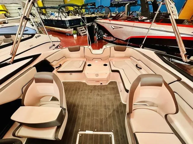 Slide: The Image of 2024 Yamaha Boats SX190 interior with spacious seating and modern design in a showroom. - 8