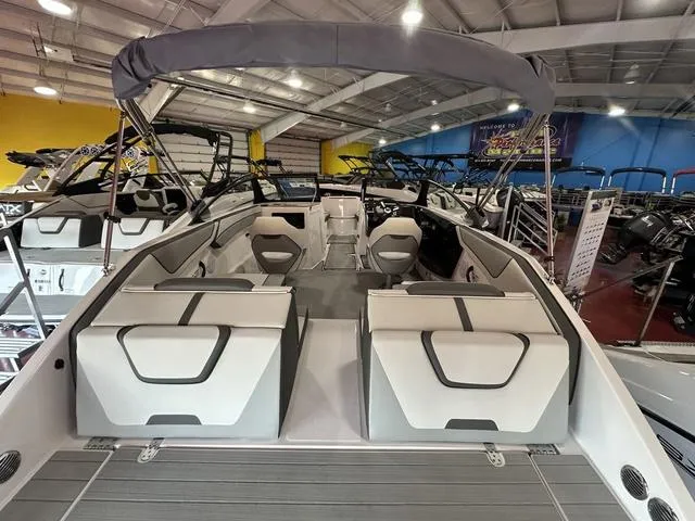 Slide: The Image of 2025 Yamaha Boats SX220 interior, showcasing spacious seating and modern design in a showroom. - 5