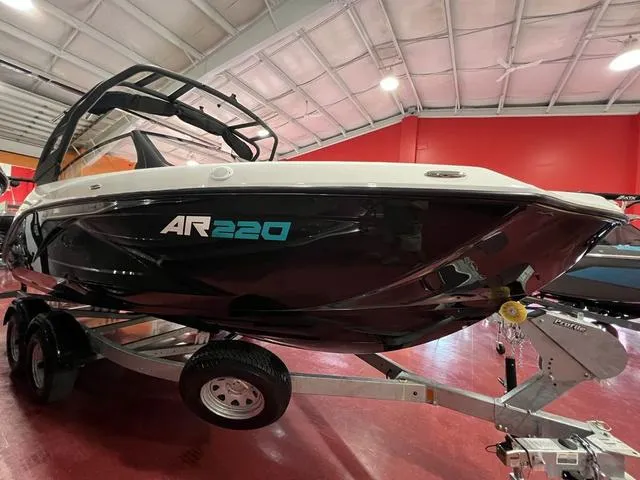 Slide: The Image of 2025 Yamaha Boats AR220 on trailer in showroom, sleek black design. - 4
