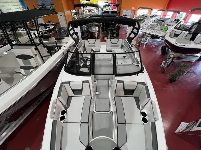 Slide: The Image of 2025 Yamaha Boats AR220 in showroom, sleek design, spacious seating, modern features. - 6