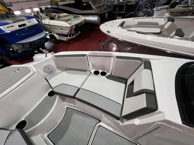 Slide: The Image of 2025 Yamaha Boats AR220 interior seating in showroom, featuring sleek design and comfortable upholstery. - 7