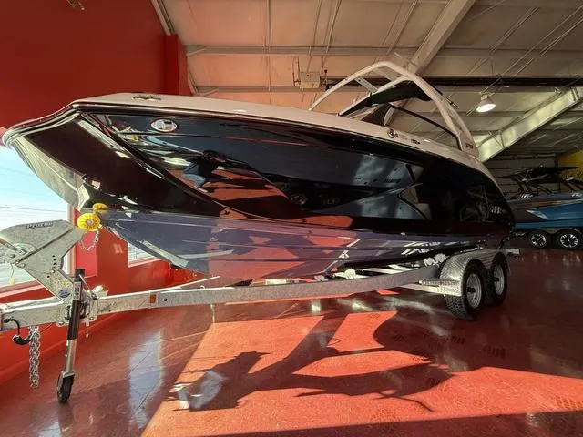 Slide: The Image of 2025 Yamaha Boats 222S on trailer in showroom, sleek black design. - 11