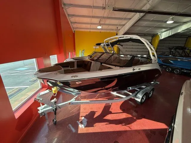 Slide: The Image of 2025 Yamaha Boats 222S in showroom, sleek black design on trailer. - 12