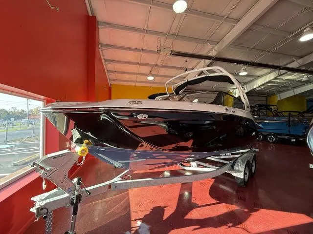 Slide: The Image of 2025 Yamaha Boats 222S on trailer in showroom, sleek black design. - 13