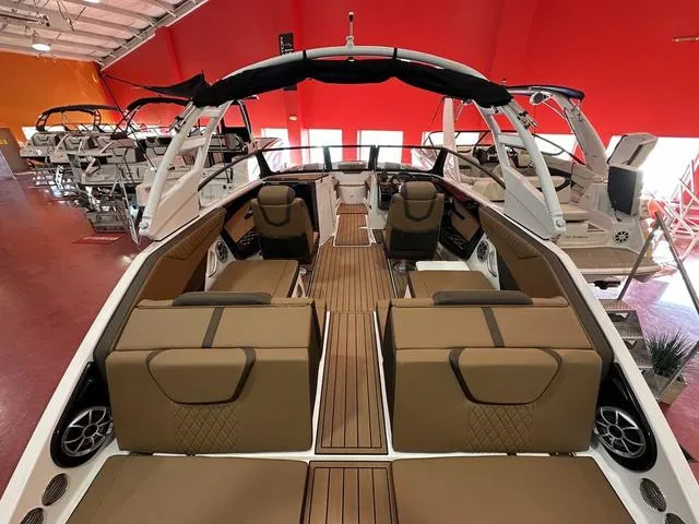 Slide: The Image of 2025 Yamaha Boats 222S interior with tan seating and sleek design in showroom. - 6