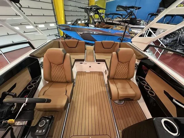 Slide: The Image of 2025 Yamaha Boats 222S interior with luxurious seating and sleek design in a showroom. - 8