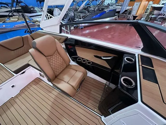 Slide: The Image of 2025 Yamaha Boats 222S interior with tan seating and sleek dashboard design. - 9