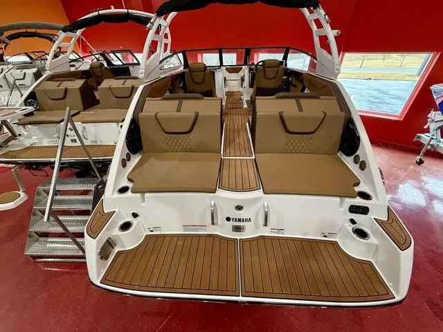 Slide: The Image of 2025 Yamaha Boats 222SD interior with brown seating and sleek design in showroom. - 4