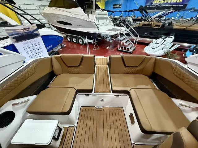 Slide: The Image of 2025 Yamaha Boats 222SD interior with tan seating and wood accents in showroom. - 6
