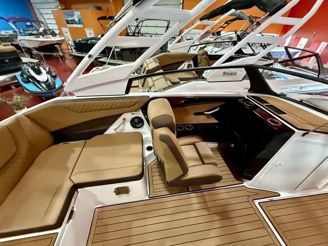 Slide: The Image of 2025 Yamaha Boats 222SD interior with tan seating and sleek design in showroom. - 7