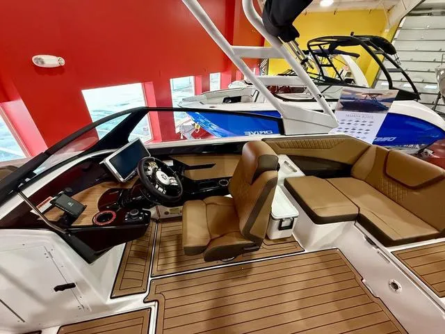 Slide: The Image of 2025 Yamaha Boats 222SD interior with modern dashboard and seating in showroom. - 8
